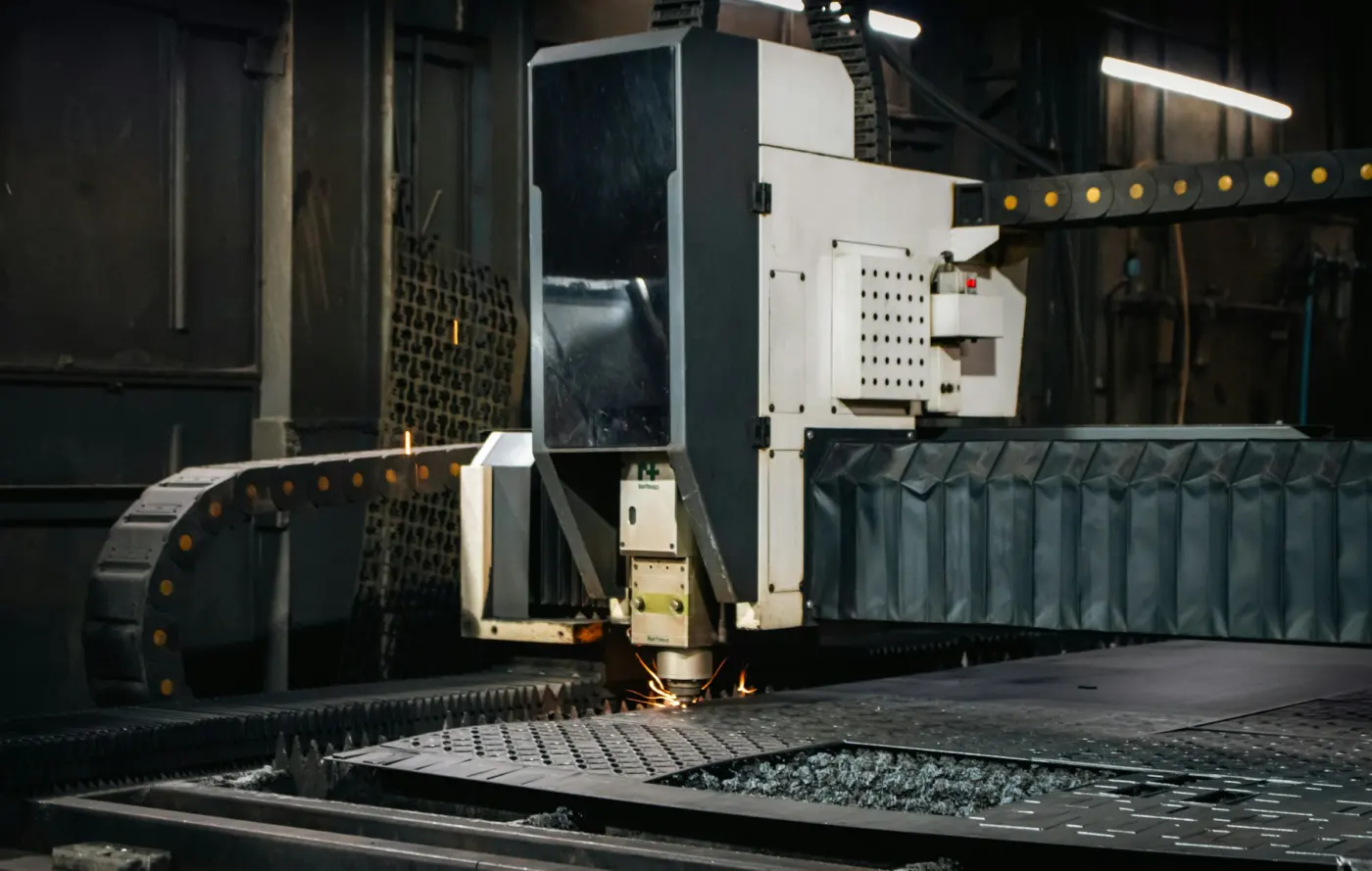 Fiber laser head cutting a steel sheet on a CNC bed