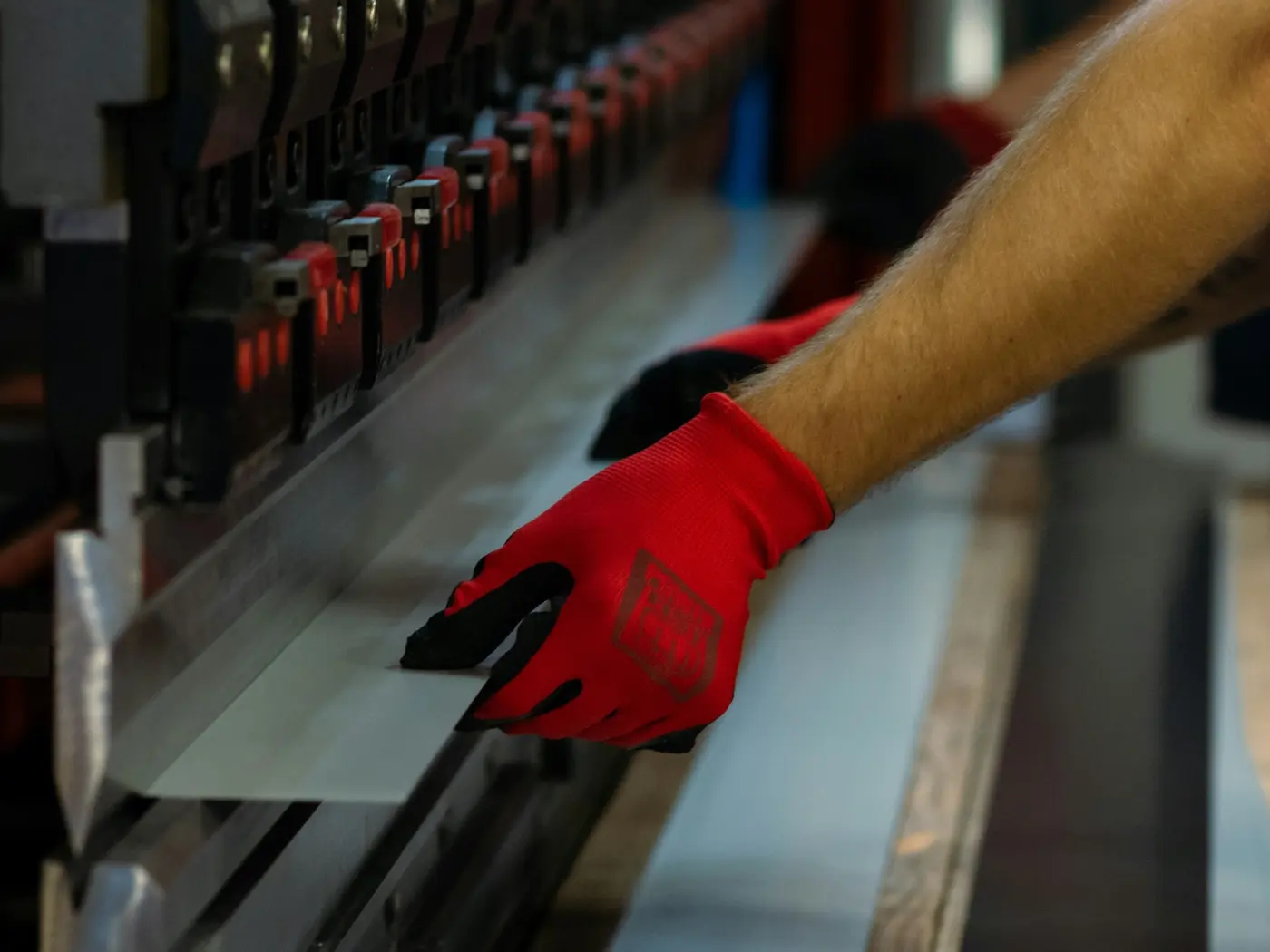 Worker positioning a metal sheet at a press brake